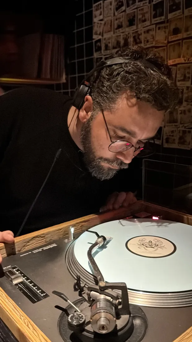 Semir Lajmi cueing a white vinyl record on a turntable